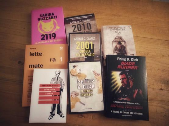 Libri su tavolo di legno

- "Blade Runner" e "In senso inverso" di Philip K. Dick
- "Buon senso e utopia" di Errico Malatesta
- "2001 Odissea nella spazio" e "2010 Odissea Due" di Arthue C. Clarke
- "Noi" di Evgenij Ivanovic Zamjatin
- "Nuova Lettera Matematica", A.A.V.V.