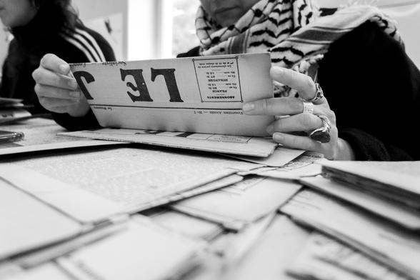 black and white picture of Marouchka reading "LE JURA", a newspaper from the 20th century.