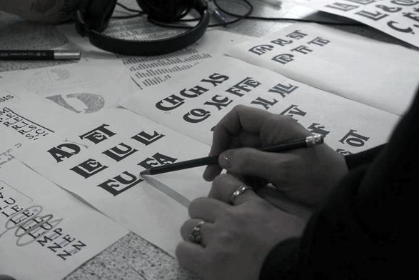 Black and white picture of someone taking notes on a list of inclusive ligatures