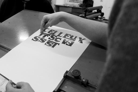 Black and white picture of someone holding a print of our glyphs painted