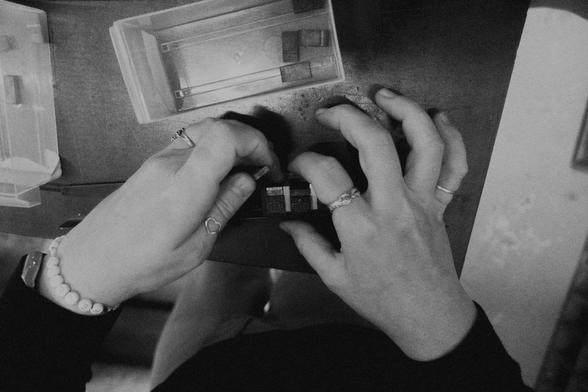 Black and white picture of someone composing text for analog print on press.