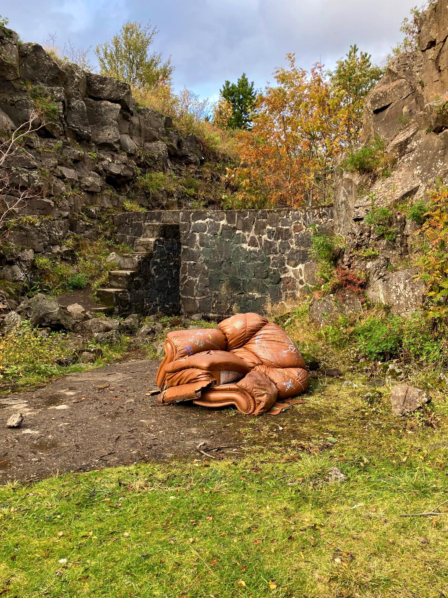 A brown chair left to decay in nature.