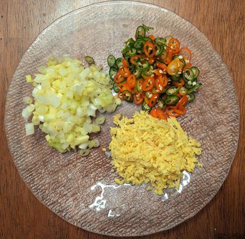 Chopped ingredients on a small plate. Ginger is minced or at least chopped finely