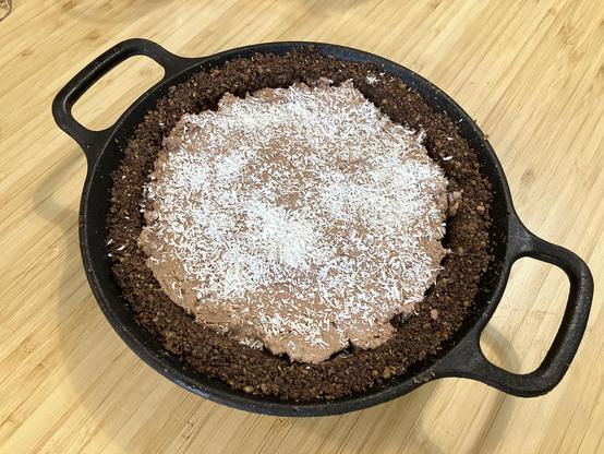 A chocolate crusted ice cream pie topped with coconut.