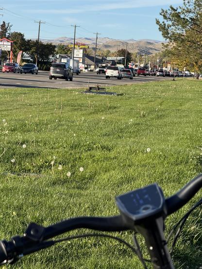 Traffic backing up on NB Glenwood Rd. A lovely grass buffer between the road and the bike/pedestrian path. My bike in the foreground.