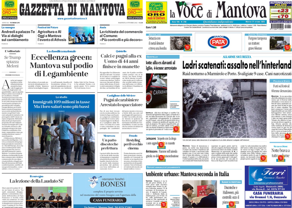 Due prime pagine di giornali. L'immagine mostra le copertine della "Gazzetta di Mantova" a sinistra e de "La Voce di Mantova" a destra, visualizzate su uno schermo in un ambiente buio. I titoli principali della Gazzetta di Mantova riguardano l’eccellenza green di Mantova e alcune notizie di cronaca locale. Nella Voce di Mantova il titolo principale parla di un assalto di ladri nell’hinterland mantovano. Entrambe le pagine hanno varie notizie locali, foto e annunci pubblicitari.