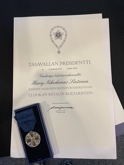 Image of "First Class Medal of the White Rose of Finland with golden cross" and the associated diploma.