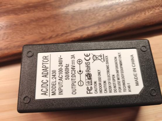 Gehäuse eines Netzteils.
Es gehen 220V und es sollen 24V mit 3A raus kommen. Liegt auf einem Holztisch.