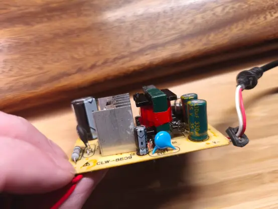 Platine von der Seite mit so Elektrozeug drauf gelötet. Erkenne da sowas wie nen Widerstand und ein paar Kapazitatoren... (ich hab von dem Kram keine Ahnung!)