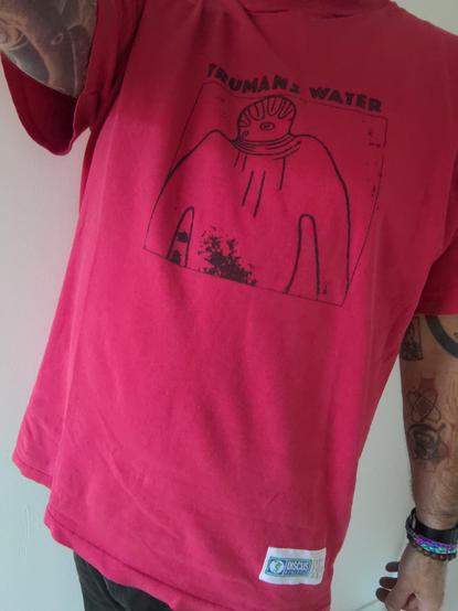 Moi avec mon vieux t-shirt Trumans Water : Dessin imprimé DIY par le groupe lui-même sur un vieux t-shirt de sport on voit l'étiquette Dscuss Athletic en bas du t-shirt.