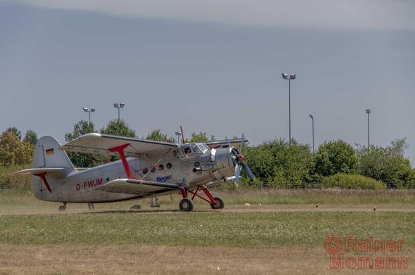 Farbfotografie im Format 3:2 Landscape.
Ein silberfarbener Doppeldecker der Firma Antonov, mit der Bezeichnung AN2, kurz vor dem Start, auf dem Rollfeld des ehemaligen Flugplatzes Oberschleißheim.