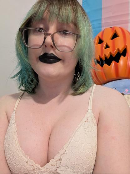 Revy wearing black lipstick and glasses and a pumpkin is in the background