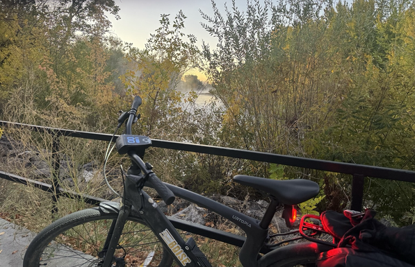 Water vapor coming off the river at Veterans Memorial Pkwy as viewed through my bike, a metal railing, and river foliage.