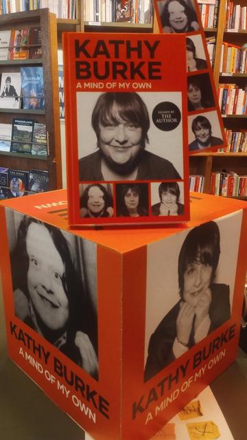 a large cube with different photos of Kathy Burke on each face, with a signed, hardback edition of her biography on the top, in the Edinburgh Bookshop