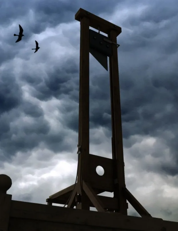 An ominous looking guillotine on a blustery day. Two ravens are flying by.   the-guillotine-large – History of Sorts dirkdeklein.net