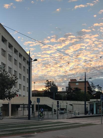 Un cielo emborregado sobre los paseíllos universitarios. A la izquierda el edificio politécnico y en primer plano, las vías del metro.
