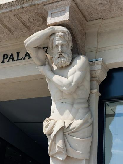 Stone sculpture supporting a beam instead of a tectonic support. The sculpture is a bearded, naked man wearing only a cloth wrapped around his hips. His left arm supports his right arm carrying a balcony cornice on his shoulders. 
What a man, what a man, what a man, what a mighty strong man...