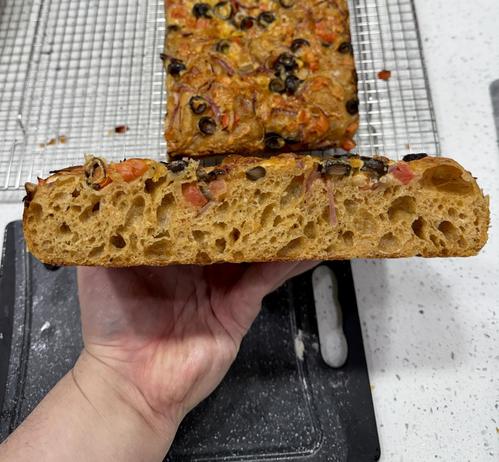 Cross section of the focaccia to show the texture of the crumb, it’s nice and airy. The dough has a reddish tone to it from the spices.