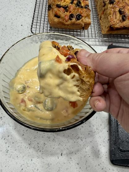 Me holding a piece of focaccia dipped in cheese sauce