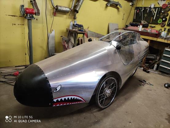 alumiininen niittaamalla kasattu kinneri joka muistuttaa vanhaa hävittäjää, musta pyöreä nokka, kaksi rengasta edessä ja yksi takana. kuskinaukon päällä katto