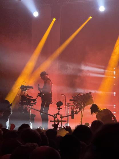 Igorrr’s multi-talented guitarist/synth/percussionist on stage, with red smoke and orange spotlights.
