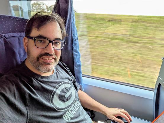 Selfie von Keywan, der im ICE sitzt und in die Kamera lächelt