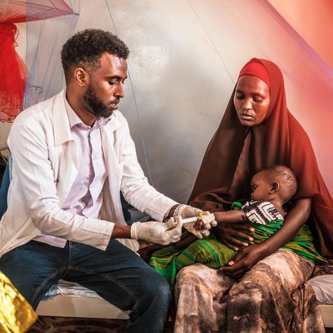 A nurse examining a baby girl at an emergency nutrition center in Baidoa, Somalia.