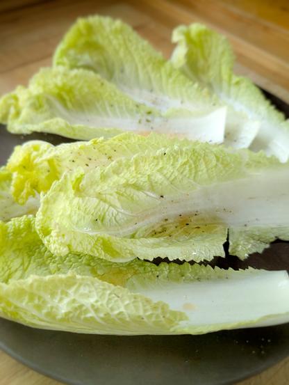 Frisch geerntete Chinakohlblätter auf einem Teller, gewaschen und gewürzt mit  leichtem Dressing, Foto by Johann Seidl, Gartenpoet.“