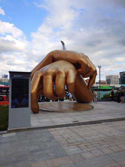 The monument to the so g Gangnam Style: two golden hands crossing lime the horse riding move in the MV