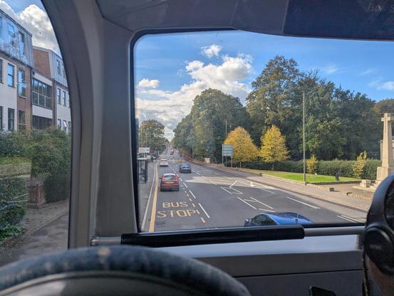 View from the top deck of a bus down a long straight road