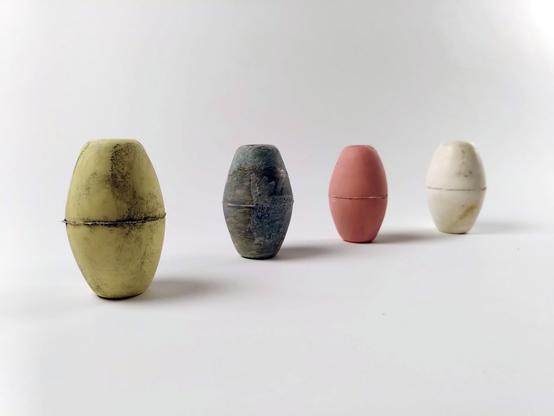 4 colored fishing net floaters displayed on a white background.
The 3 on the left are ceramic copies in yellow, grey and pink. The 4th one on the right is the plastic white original floater.