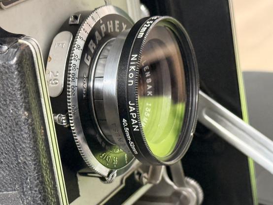 The assembled filter adapter, with a UV filter threaded into it, on the lens of the Crown Graphic