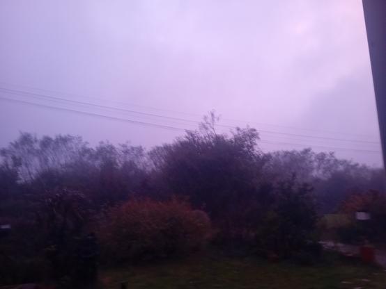 Les couleurs du ciel sont sombres et rougeâtres et sous un déluge avec du vent