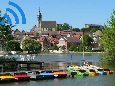 Vido de la malnova parto de Beblingo kun preĝejo, lago kaj boatoj