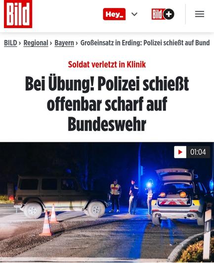 Nächtliche Straßenszene. 3 Polizisten, ein Auto.
Darüber die Bildzeitung Überschrift "Bei Übung! Polizei schießt offenbar scharf auf Bundeswehr"