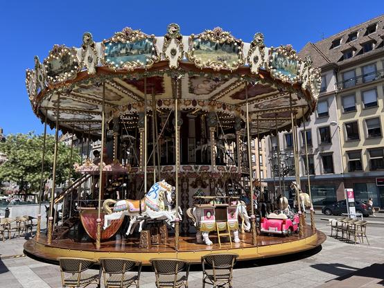 Ein wunderschönes, zweistöckiges, altes Karussell auf einem Platz mitten in der Stadt.
