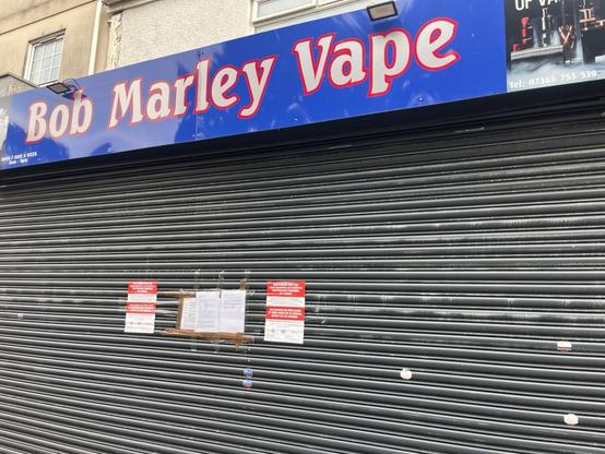 Closed Bob Marley Vapes store in Swansea city centre with shutters down and official council closure notices displayed.