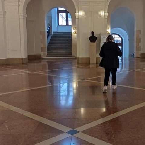Eine Frau läuft durch das ehrwürdige Foyer vom Neuen Rathaus.