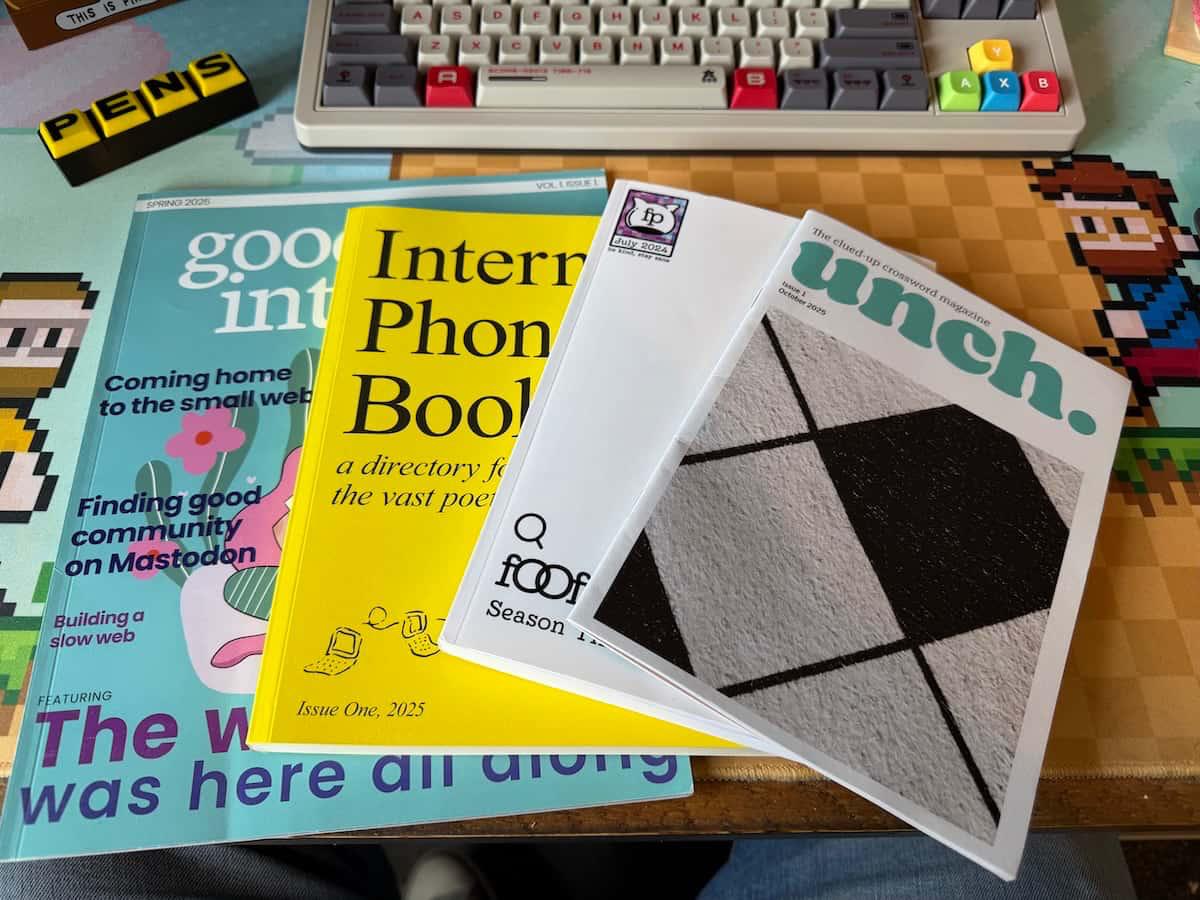 Four magazines on a desk - Good internet, the Internet Phonebook, a book by Foofaraw, and Unch crosswords