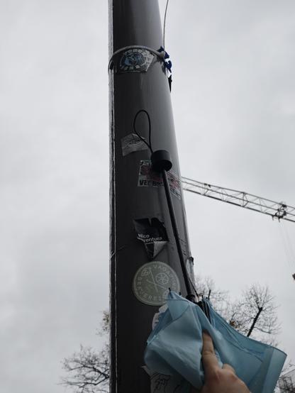 Man sieht eine Laterne und es wurde ein Sticker mit einem Regenschirm zerkratzt.