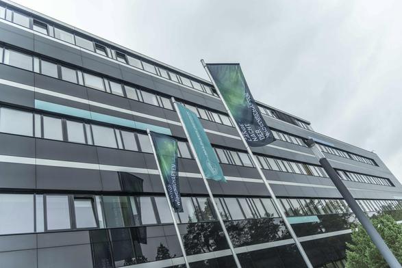 Flags with the logo of the Lange Nacht der Wissenschaften are flying in front of the Max Planck Institute for the Science of Light.