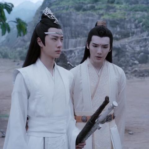 Lan Wangji stands staring straight ahead, holding both his sheathed sword Bichen and Wei Wuxian's Suibian in his left hand down by his hip. Jin Zixuan stands just beyond, gaze directed toward the pair of swords with brow faintly furrowed and mouth slightly open, indicating the image has caught him in the middle of a question.