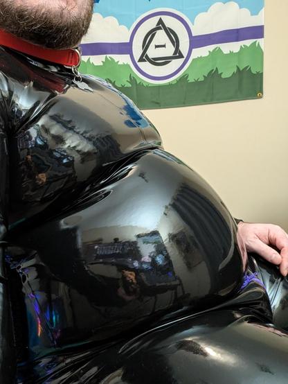 photo from the side to better show off belly size and shape, and also showing a therian flag behind me on the wall. it's more level with my belly.