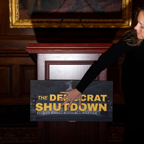 An aide places a sign on a lectern at the Capitol on Thursday, before a news conference with House Republican leadership. The House is in recess.
