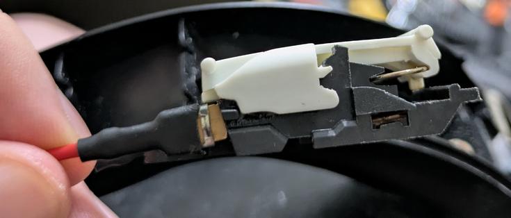 a side view of the switch, showing that there is a circular metal spring-like thing that causes the plastic top part of the switch to "clunk" into place in either the on or off position