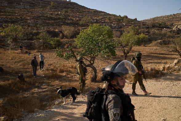 Colonos israelíes y elementos de las tropas israelíes en el pueblo de Sa'ir, en Cisjordania, este jueves.