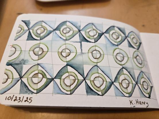 Hand drawn generative/procedural are in ink on an open page of my sketchbook. The abstract pattern looks a bit like ceramic tiles with curves and straight lines.