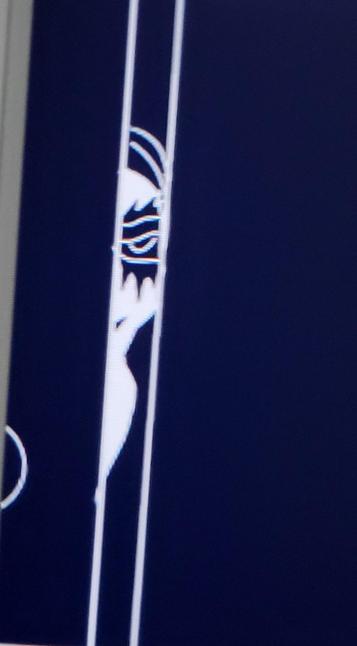 A zoomed in black and white image of and eye and head peaking through a door crack.