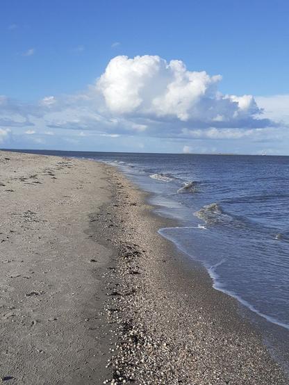Sand, Sonne Meer und weiße Wolken