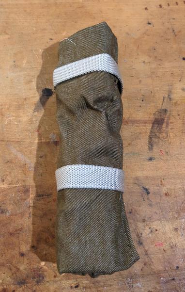 Fabric rolled around the parts in a tight burrito and strapped with velcro.